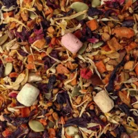 Infusion d'Halloween : Photo de l'infusion vue de haut. Tous les ingrédients sont visibles dans un mélange multicolore : carotte, hibiscus, chamallows, noisettes...