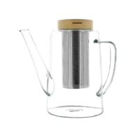 Photo de la théière en verre OGO - 1,2L. Le verre est transparent, la théi!ère est arrondie en bas et se rétrécie en remontant. Le bec verseaur remonte pratiquement en vertical. Le filtre en acier inoxydable est apparent ainsi que le couvercle en bois.