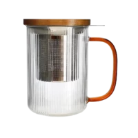 Photo de la tisanière en verre OGO - Anse ambre, 47,5cl. Le verre est transparent, strié en vertical. La anse est couleur ambre en transparence. Le filtre en acier inoxydable est apparent ainsi que le couvercle en bois.