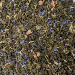 Oolong mirabelle BIO : Photo du thé vu de haut. Thé oolong peu oxydé roulé en billes décoré de jolis pétales de fleurs.