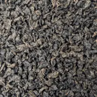 Photo du thé oolong Pinglin Chin-xin vu de haut. Feuilles roulées en petites perles. Couleur foncée dans les tons marron.