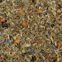 Photo de la tisane Belle des bois vue de haut. Toutes les plantes (verveine, feuilles de fruitiers, citronnelle...) et les morceaux de pomme et myrtilles...sont visibles. Les feuilles de verveine sont légèrement coupées.