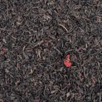 Photo du thé noir Cerise vu de haut. Thé à petites feuilles brillantes parsemé de morceaux de cerise.