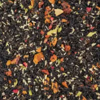 Photo du thé noir Perséphone vu de haut. Thé à petites feuilles bien sombres agrémenté de coco râpée, grains de grenade, framboises et morceaux de pomme