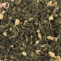 Photo vue du dessus de L'Île aux Parfums, thé vert Sencha (feuilles plutôt longues) parsemé de fleurs de jasmin et de pétales de rose.