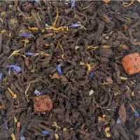 Vue de haut du thé sombre fermenté Passion Pu'er parsemé de fleurs de bleuet et de morceaux de mangue