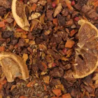 Vue de haut de l'infusion Quartiers Rouges montrant les morceaux de pomme, le rooibos vert, les rondelles de mandarine et le poivre rose