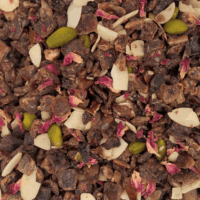 Vue de haut de l'infusion Velours Pistache montrant les morceaux de datte, pistaches, amandes effilées et pétales de rose